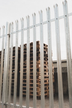Wooden pallets stacked neatly in a bright industrial warehouse.