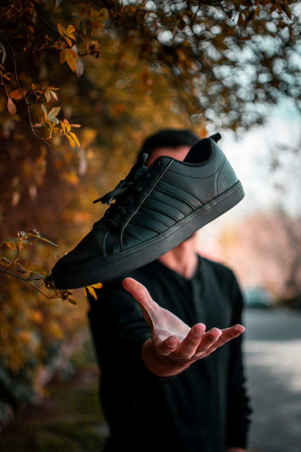 person holding black nike sneaker