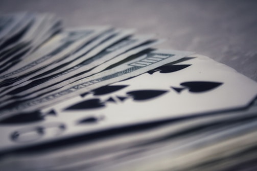 A vibrant graphic showing stacks of cash and rummy cards.