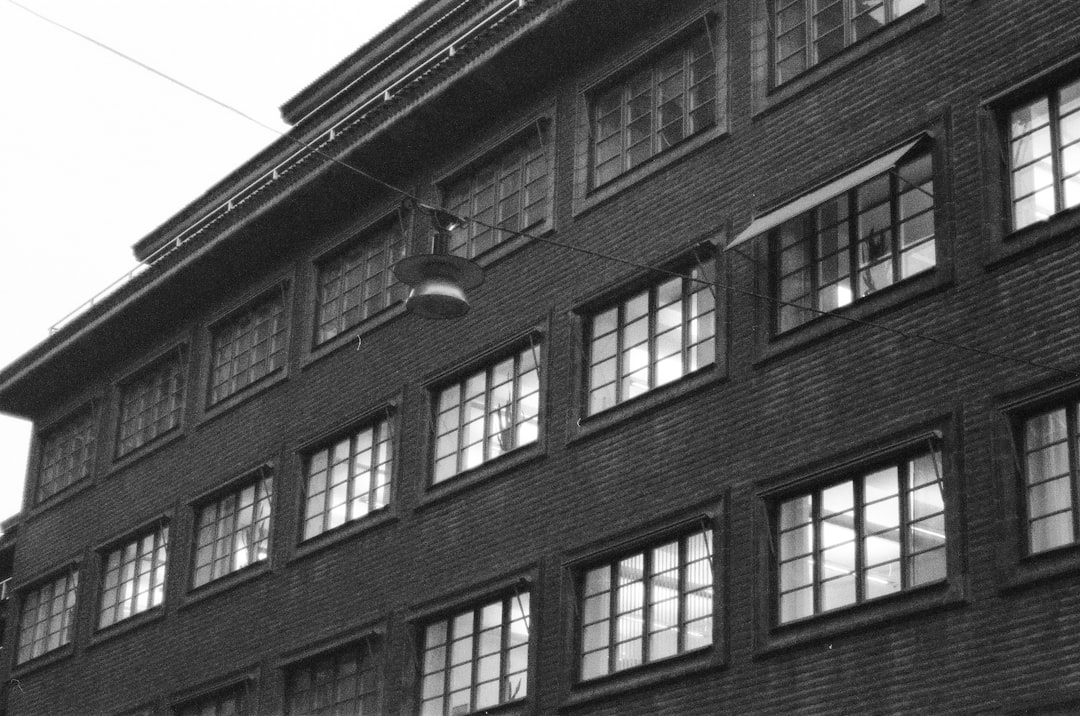 grayscale photo of building with glass windows