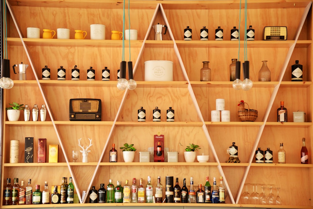 clear glass bottles on brown wooden shelf