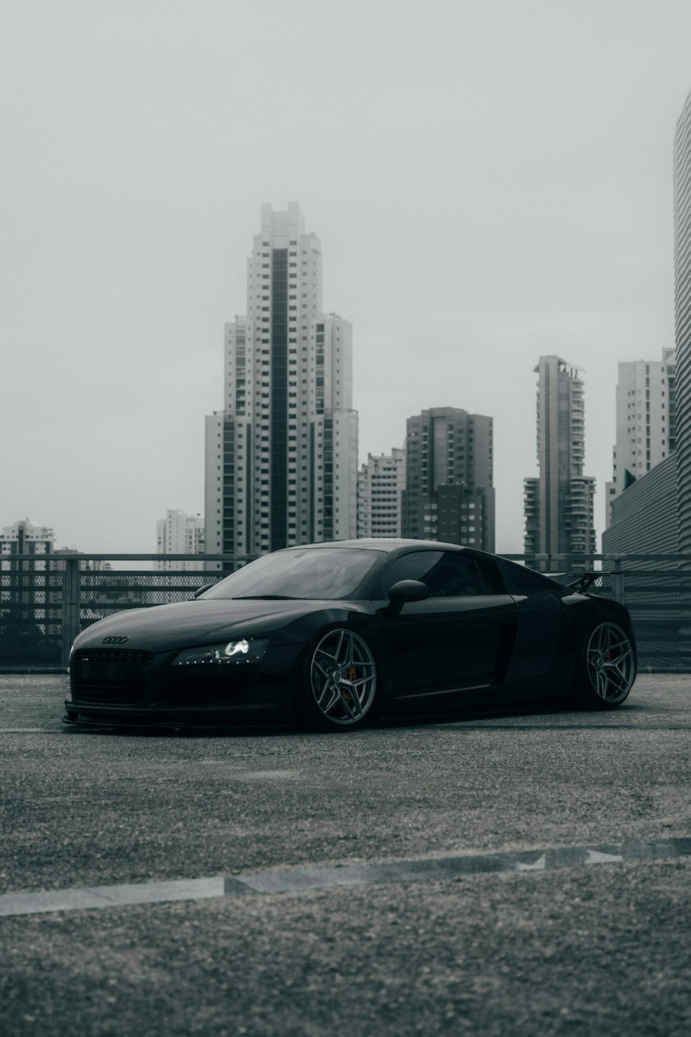 black porsche 911 parked on gray pavement near city buildings during daytime