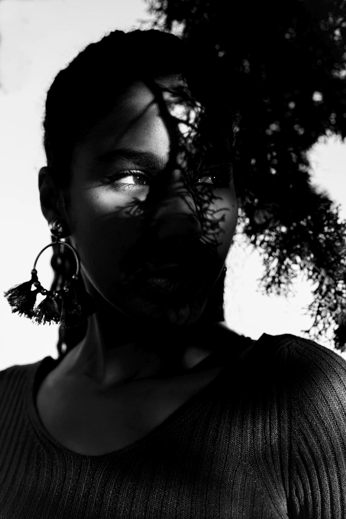 Temporary black-and-white portrait of a Black woman wearing large tassel earrings for Alex's story.