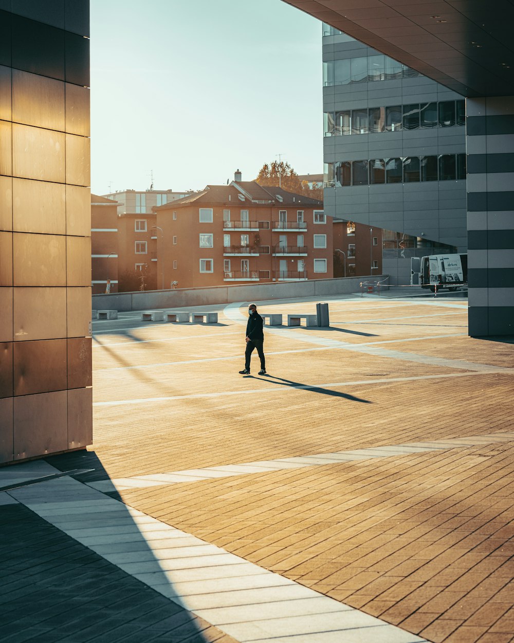 man in black jacket walking on sidewalk during daytime