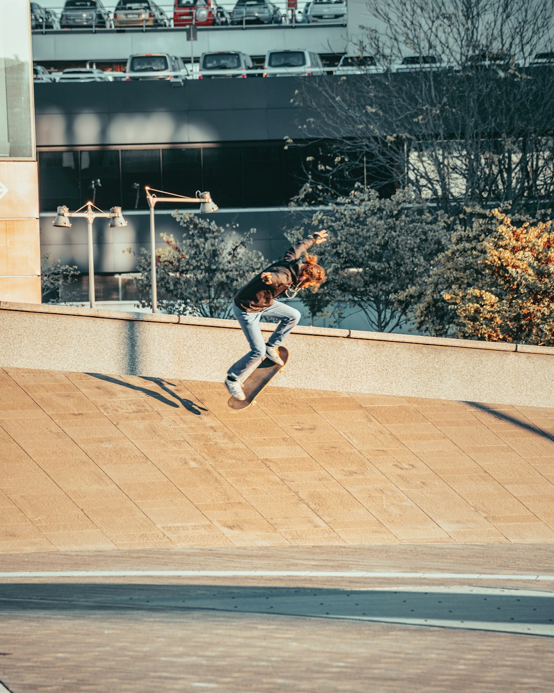 man in black jacket and blue denim jeans jumping on mid air during daytime