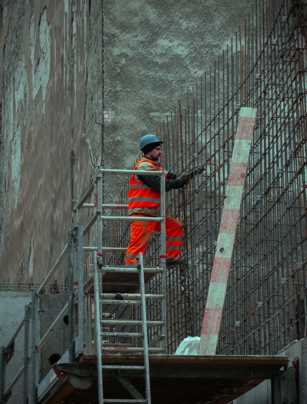 Hombre con chaqueta roja y gorra azul de pie en la escalera