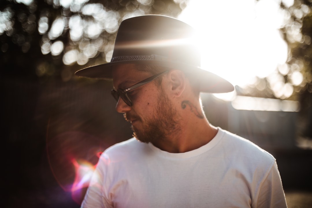 man in white crew neck shirt wearing white hat