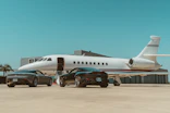 A private jet waiting on a runway ready for luxury travelers to board.