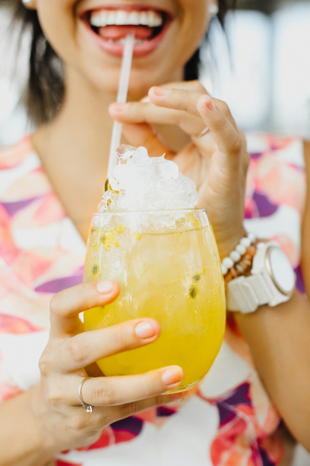 woman in white shirt holding clear drinking glass with yellow liquid