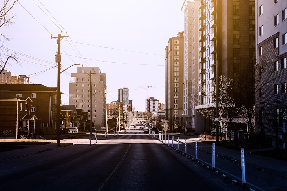 gray concrete road between high rise buildings during daytime