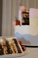 Close-up of a decadent layered cake with delicate pink frosting and golden accents.