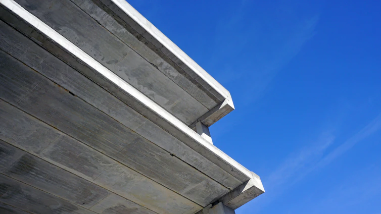 Close-up of a flawlessly finished concrete driveway with sharp edges, set against a modern luxury home in Denver.