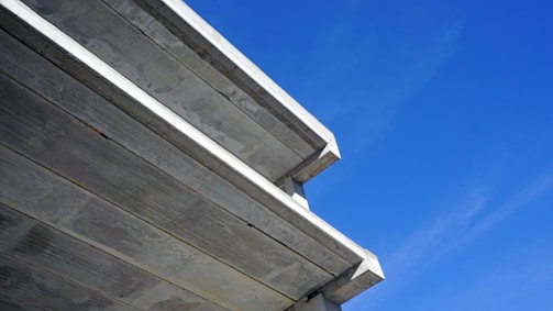 Close-up of a modern concrete driveway featuring a sleek, dark blue border with curved corners.