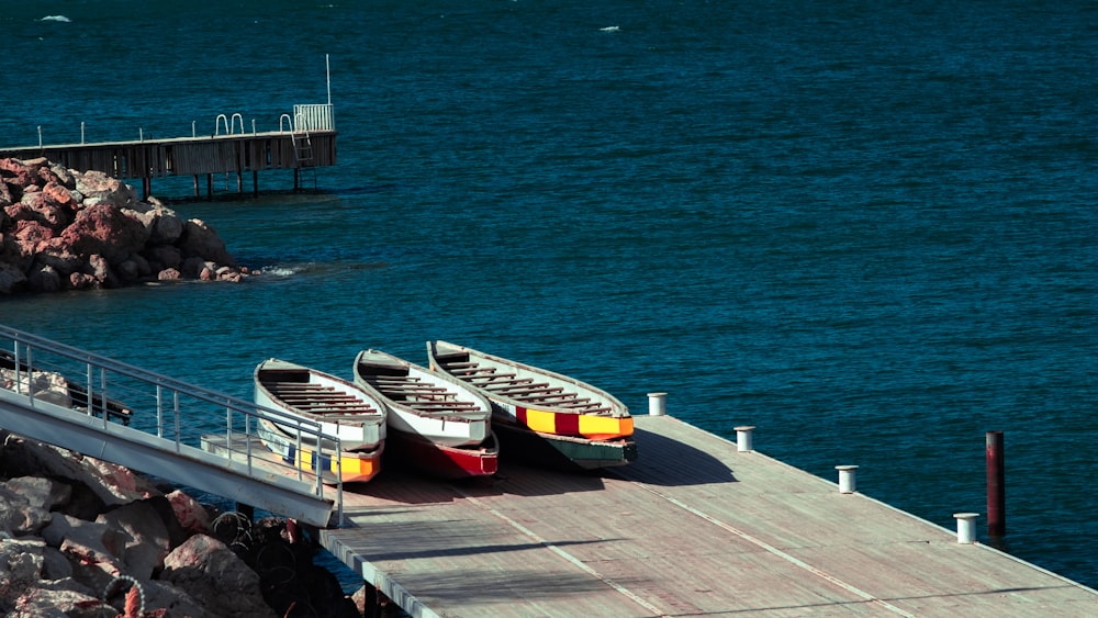 white and yellow boat on dock during daytime