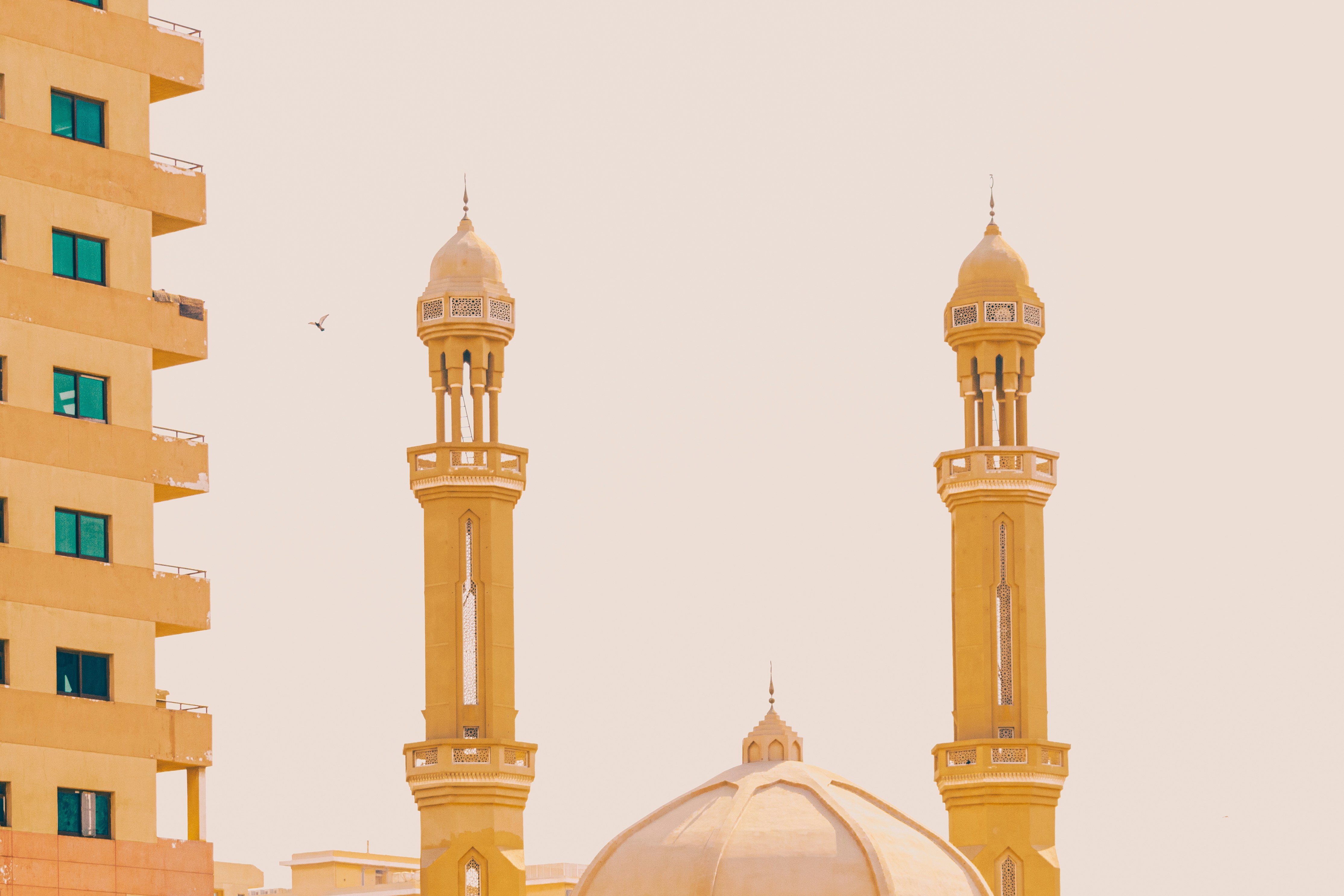 white and gold mosque under white sky during daytime