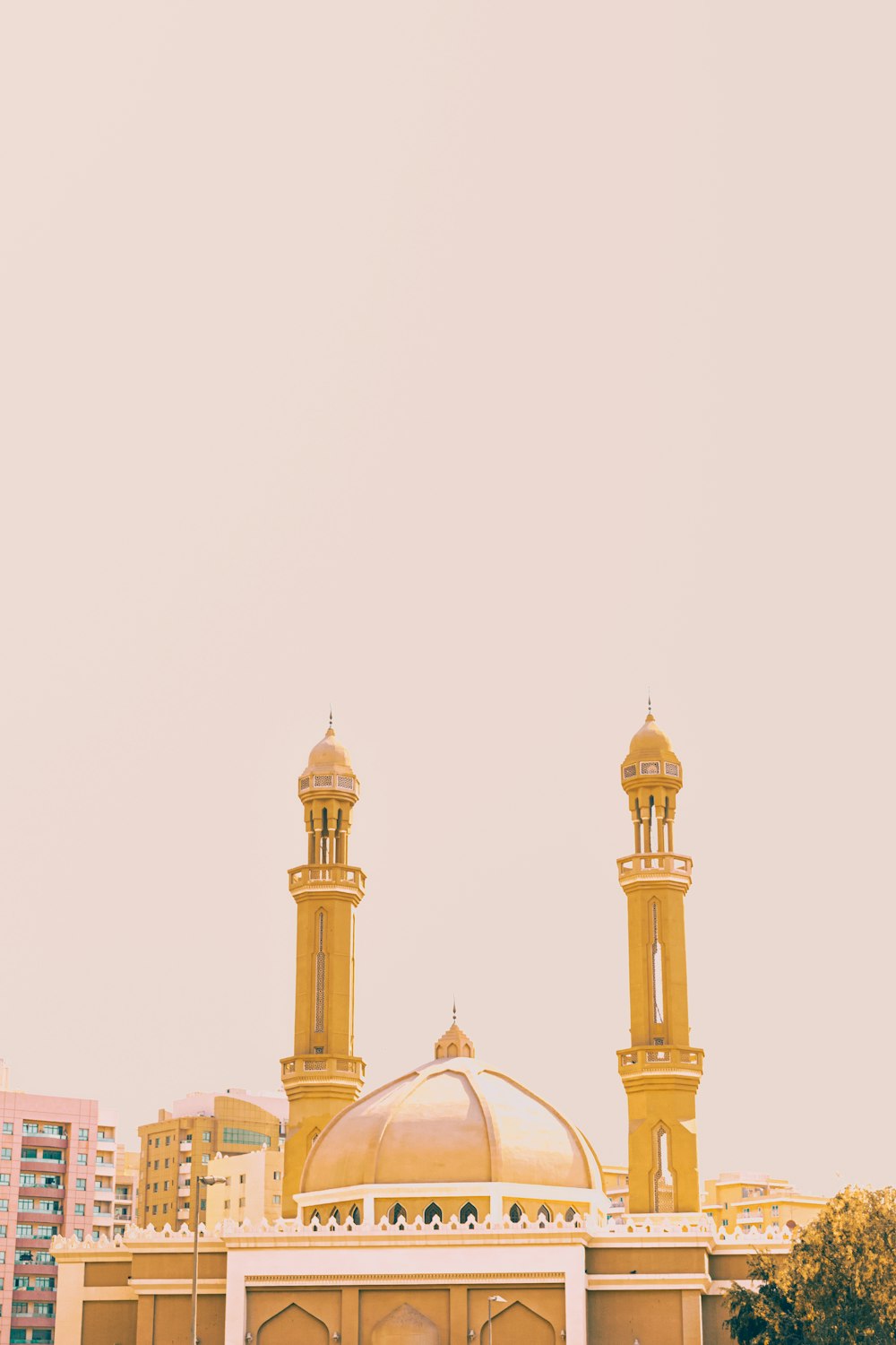 white and gold mosque under white sky during daytime