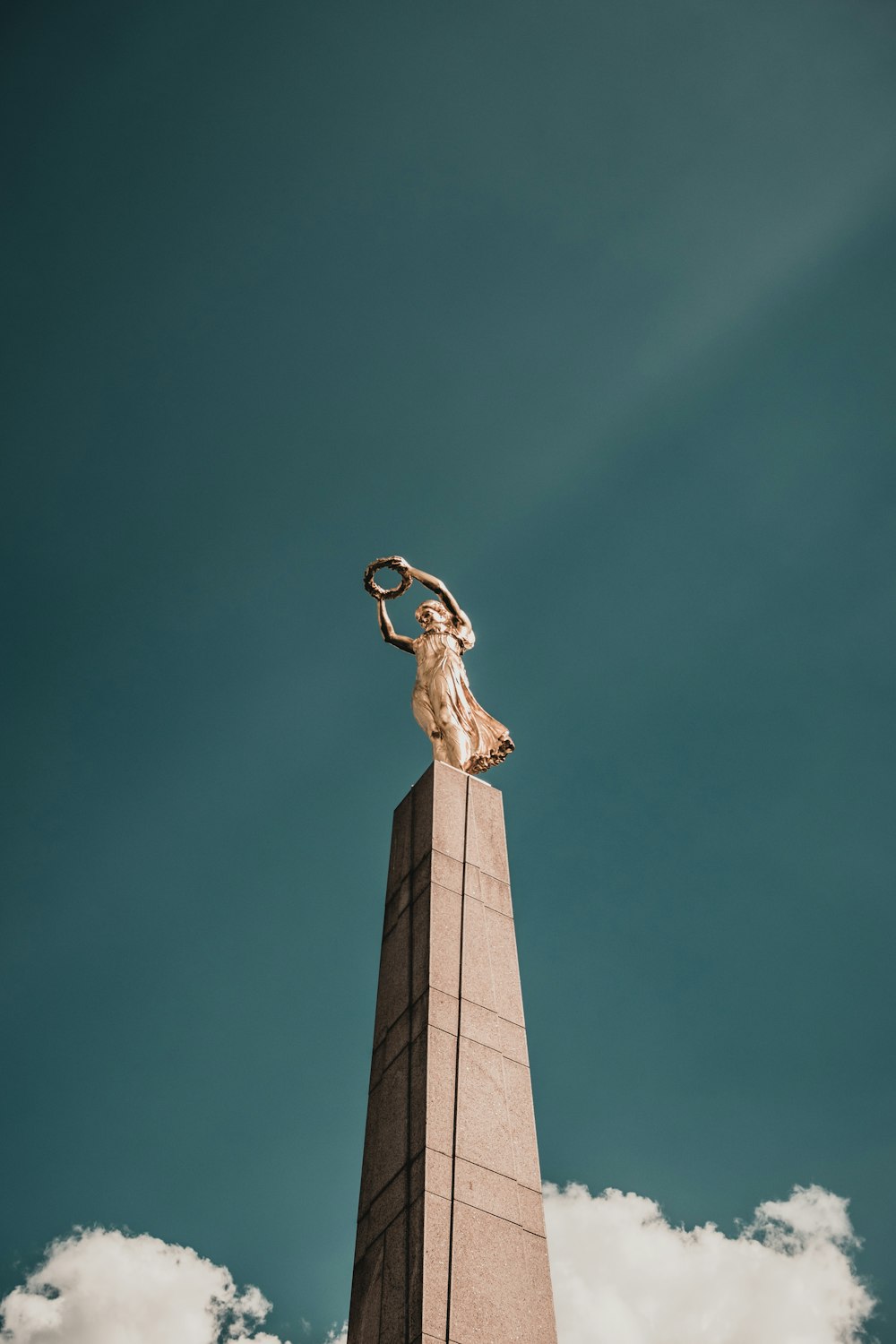 gold statue under blue sky