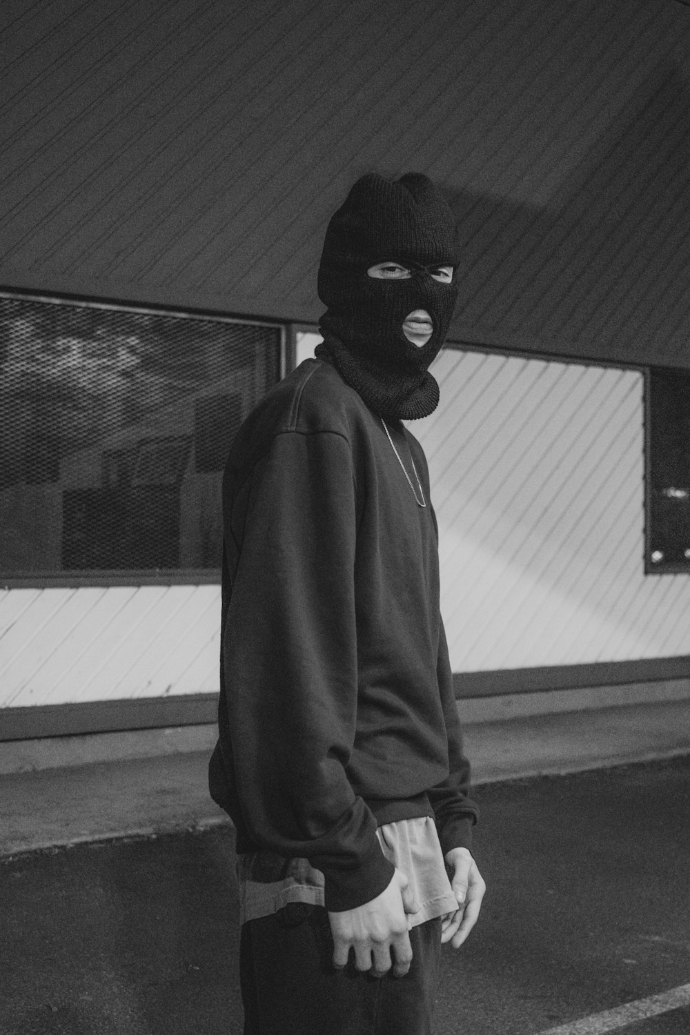 person in black mask and gray coat