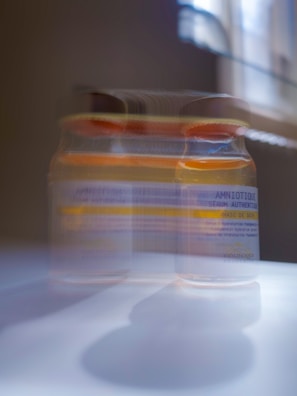 Close-up of a glowing skincare serum bottle with dewy light reflections.