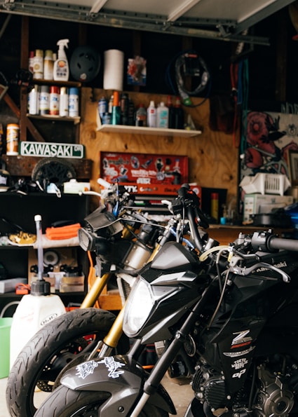 black and white motorcycle parked beside brown wooden table