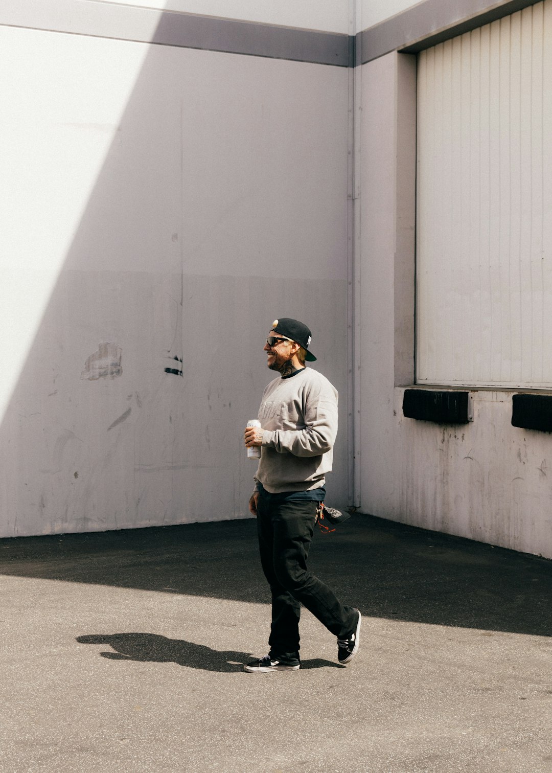 man in white long sleeve shirt and black pants standing on gray concrete floor