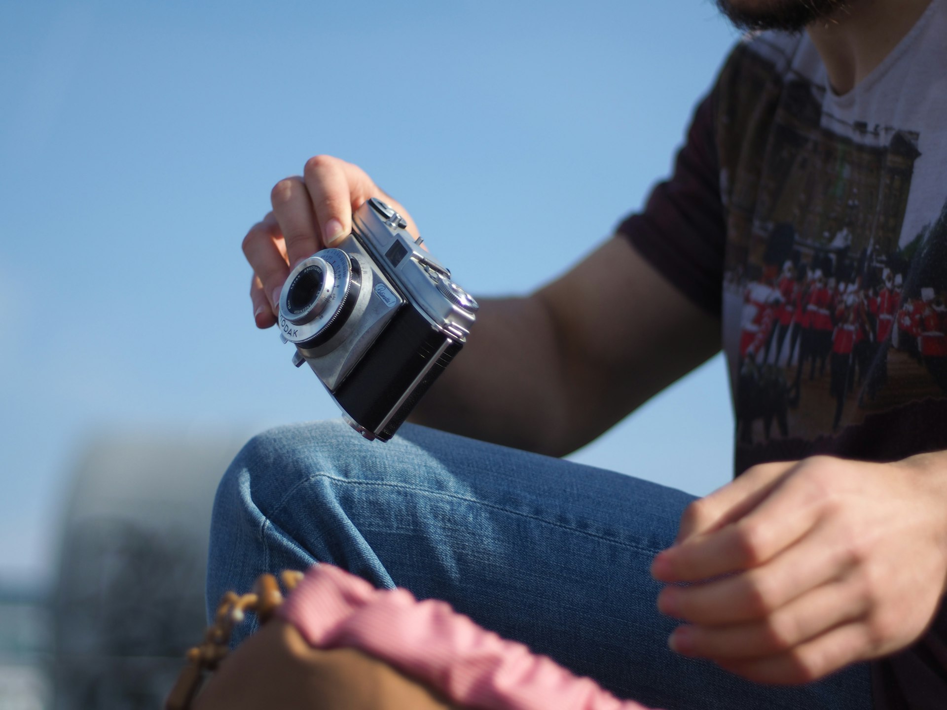 Tourist holding a film camera in front of the city panorama