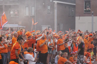 A community event with people gathered, banners in saffron and white colors.