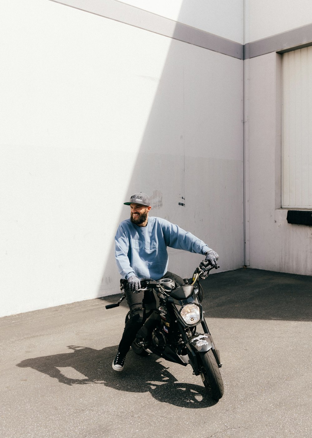 man in blue jacket riding on black motorcycle