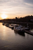 Sunset view over a calm river with rafting boats docked along the shore.