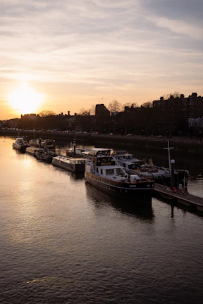 Sunset view over a calm river with rafting boats docked along the shore.