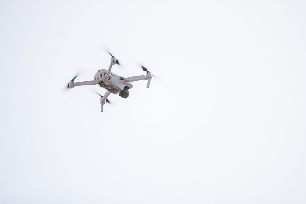 white and brown drone in mid air
