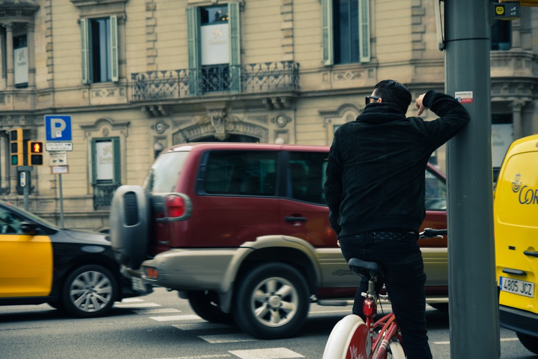 man in black jacket riding red bicycle during daytime