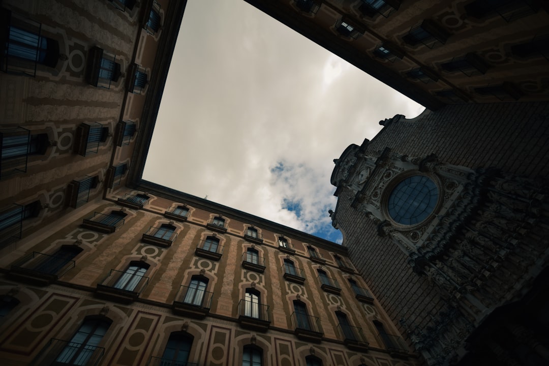 brown concrete building under white clouds during daytime