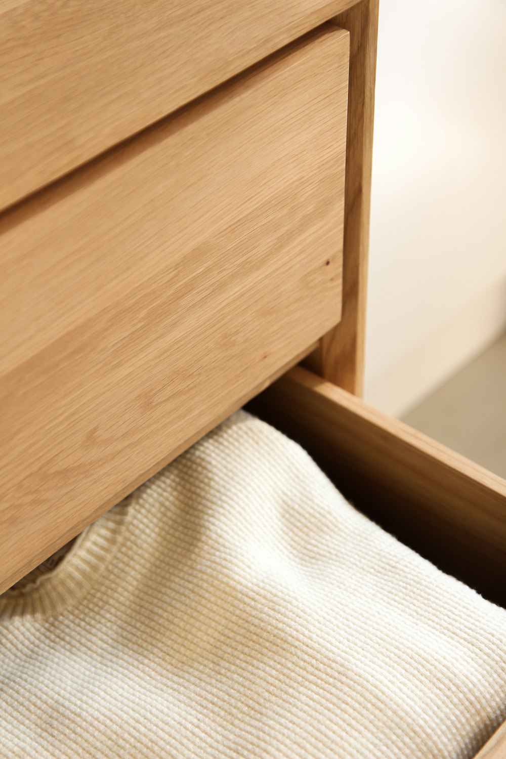 white textile beside brown wooden drawer