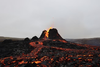 brown rocky mountain under gray sky