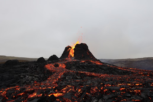 brown rocky mountain under gray sky