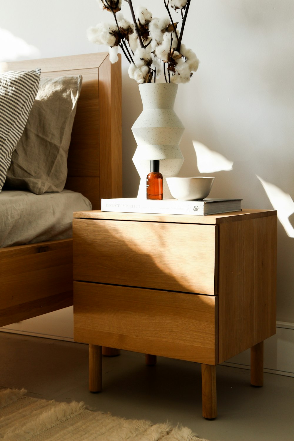 white ceramic vase on brown wooden nightstand