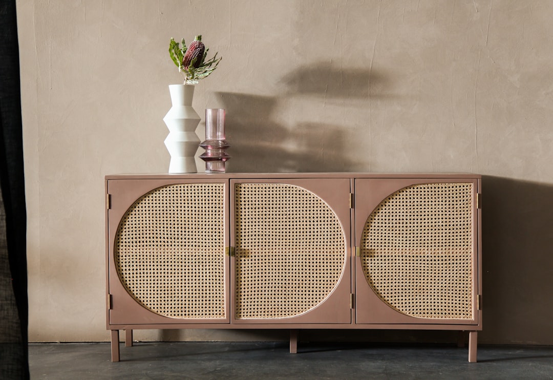 brown wooden cabinet beside white flower vase