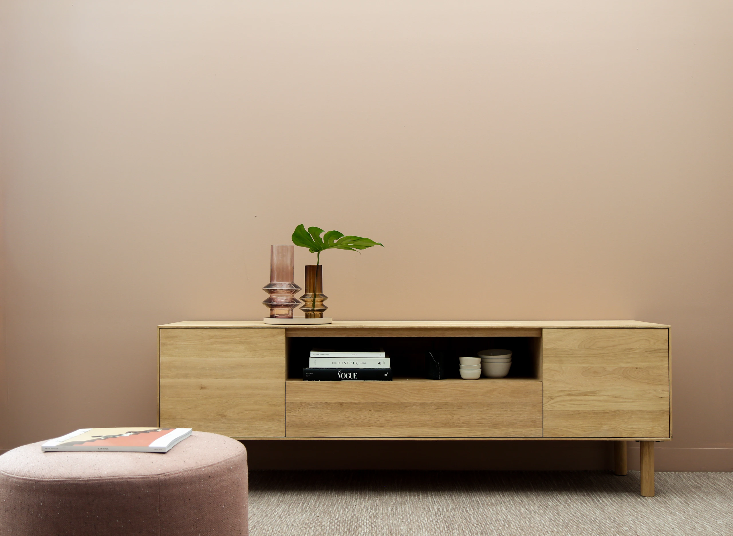 Low oak media console with a round upholstered pouf