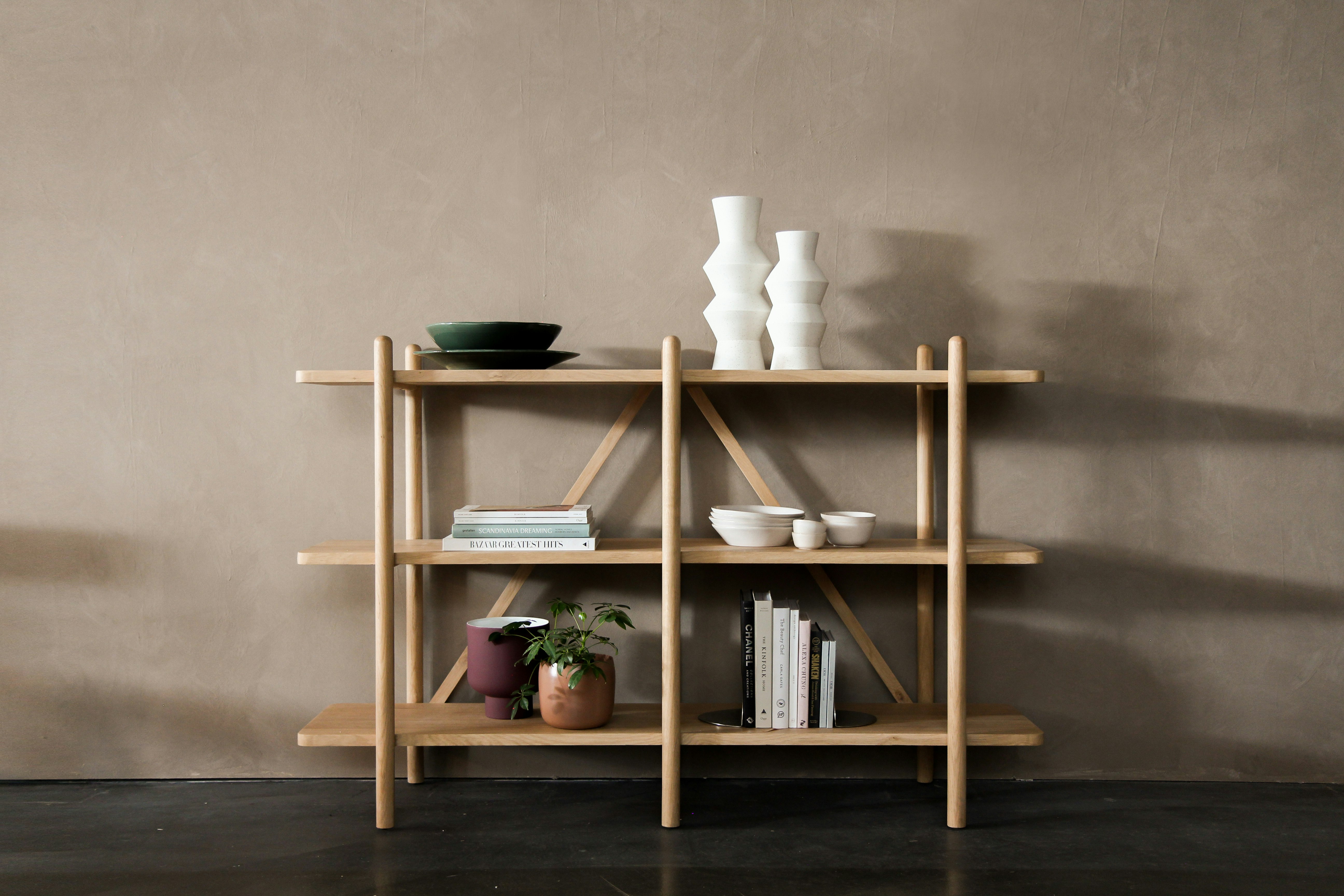 brown wooden 3 layer shelf with white pillar candles