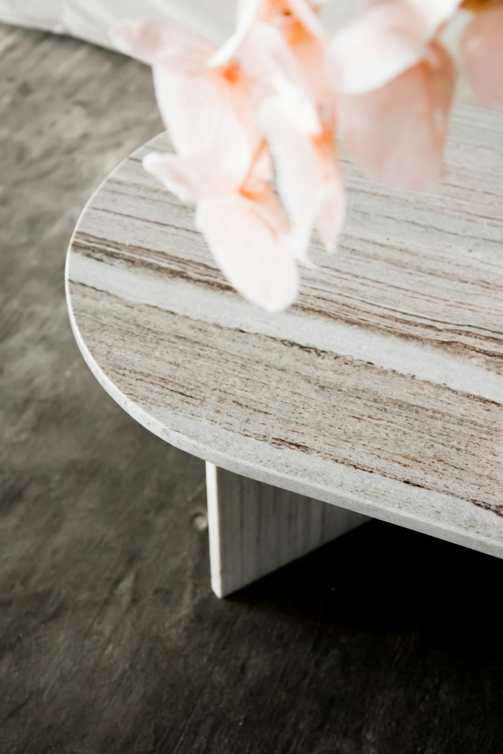 white and pink flower on brown wooden table