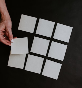 person holding white and black checkered card