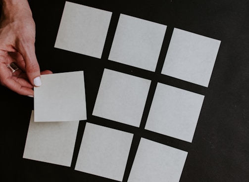 person holding white and black checkered card