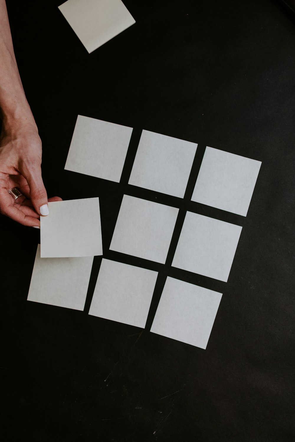 person holding white and black checkered card