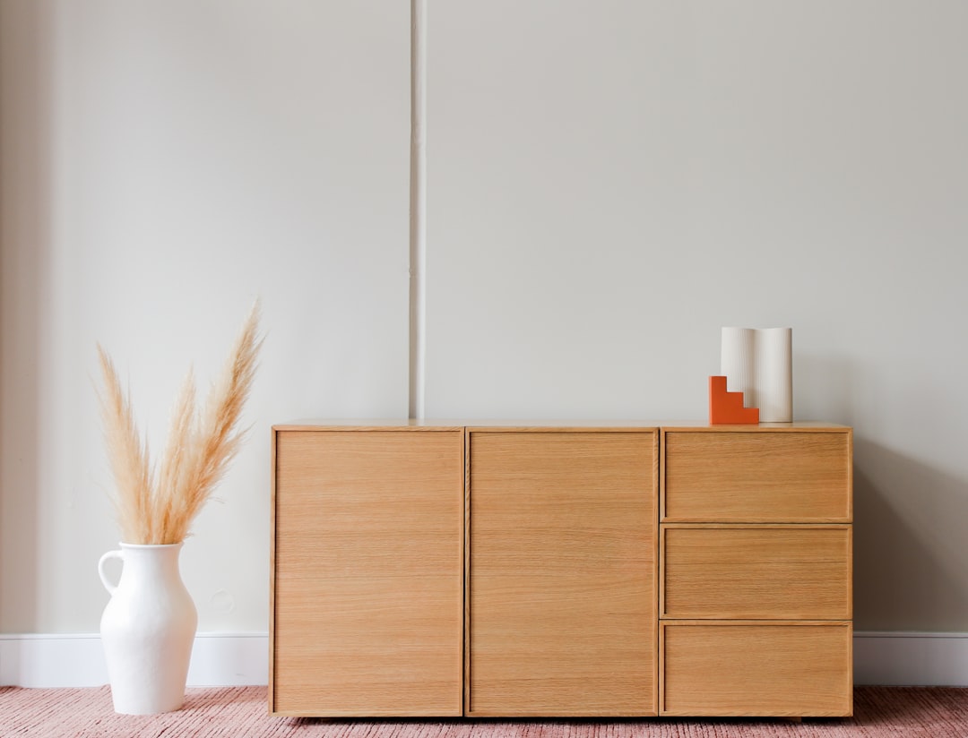 brown wooden cabinet beside white wall