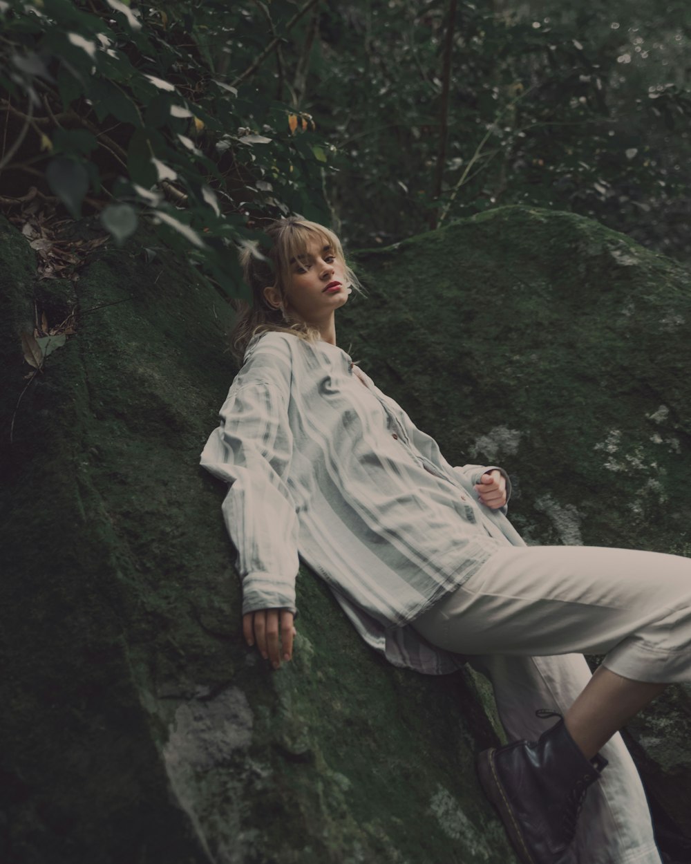 woman in white long sleeve shirt and white pants sitting on rock