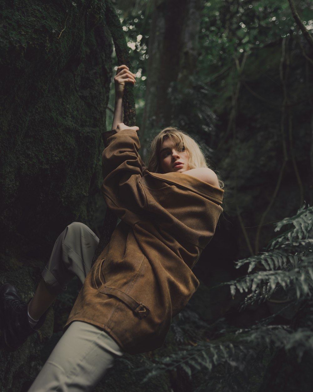 man in brown jacket holding a stick