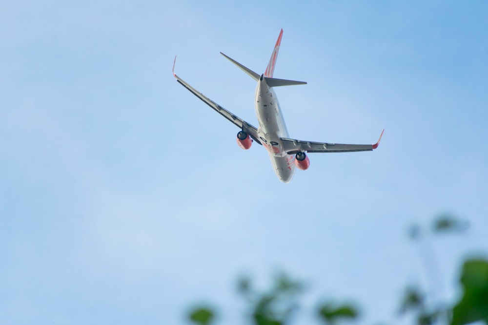 white and red airplane flying during daytime