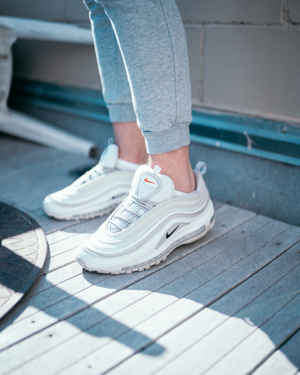 person in gray sweatpants wearing white nike sneakers photo – Free Chicago  Image on Unsplash