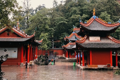 red and white temple near green trees during daytime